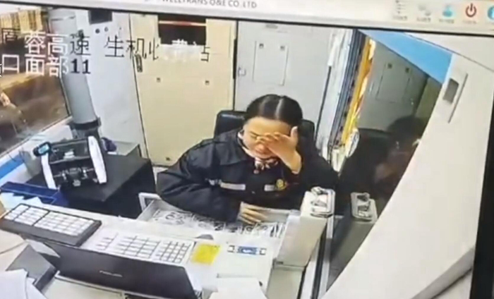 收费员低头抹掉泪水,转脸微笑服务(视频截图).jpg