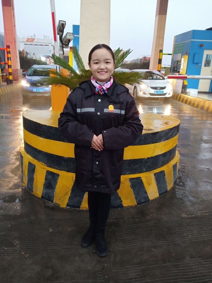 收费员翁芯在收费站前。(摄影 薛梅).jpg